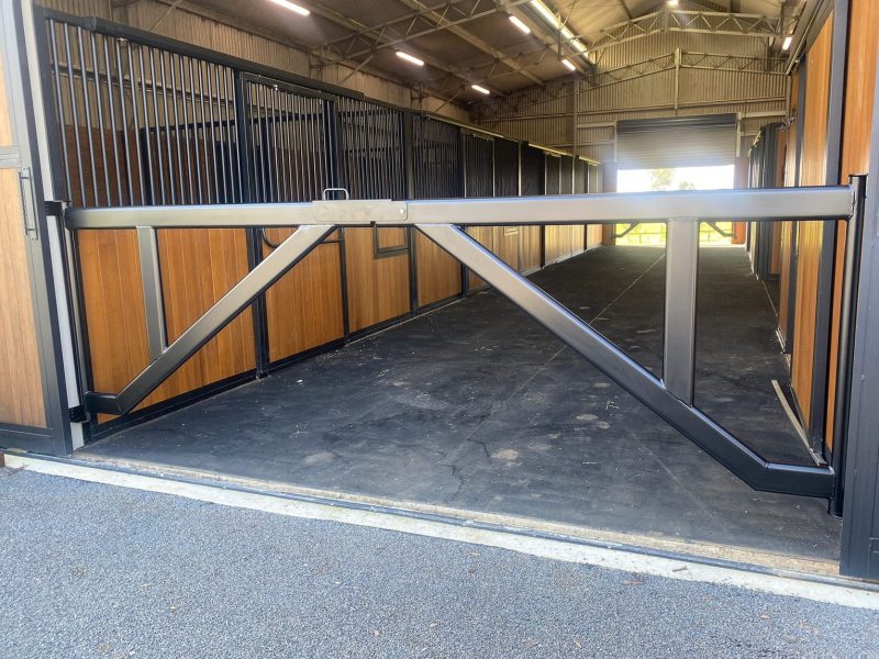 Steel-framed stable doors and partition inside a timber-lined barn